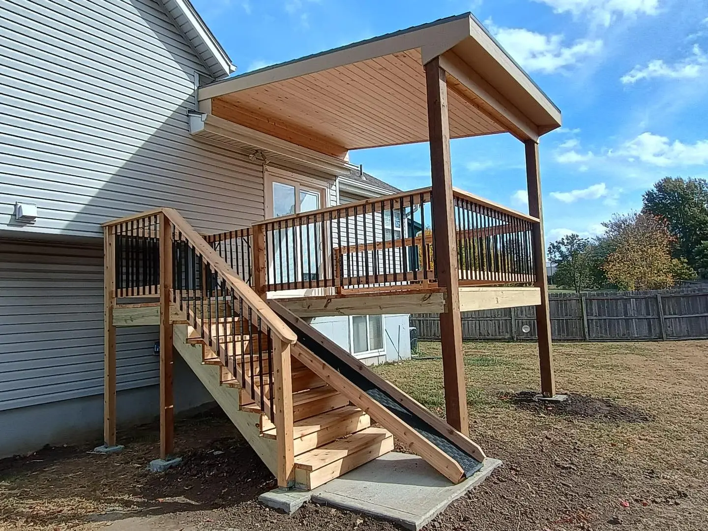 covered wooden deck with stairs attached to a suburban home in kansas city