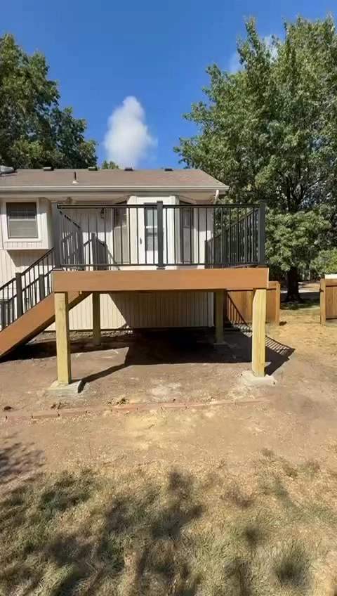 completed elevated backyard deck with black railings built by professional deck builder in Kansas City