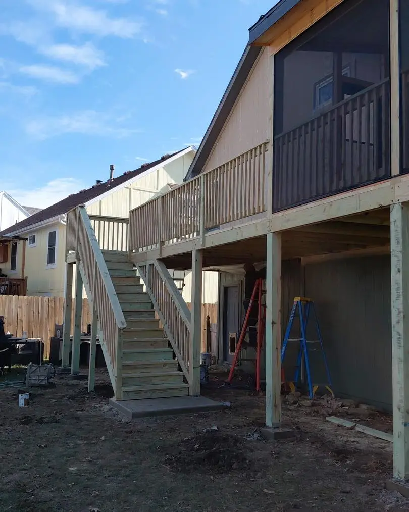 partially completed elevated custom deck construction with railing and stairs by a Kansas City deck builder