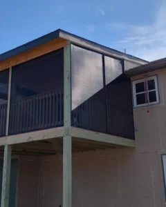 partially finished elevated deck with screened walls and wood framing attached to a house exterior