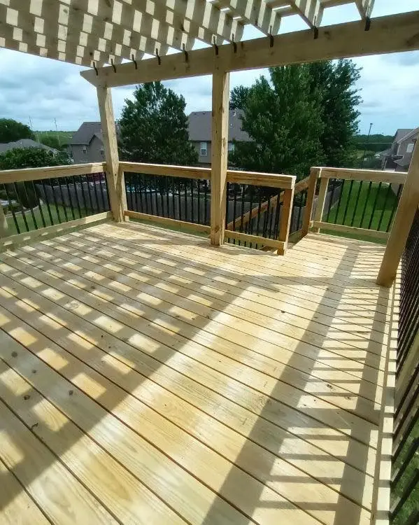 elevated wood deck with pergola and railings built by KC Deck Services overlooking a suburban Kansas City backyard