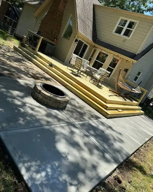beautifully maintained wood deck with patio furniture beside concrete area with fire pit showing long-lasting deck results